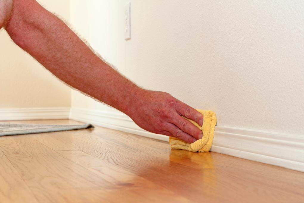 hand cleaning baseboard